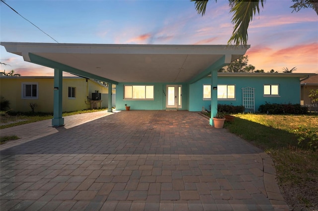 1025 Boca Ciega Isle Dr, St Pete Beach, FL 33706 - view of front of home with stucco siding, an attached carport, and decorative driveway