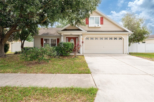 view of front facade with fence, concrete driveway, and an attached garage