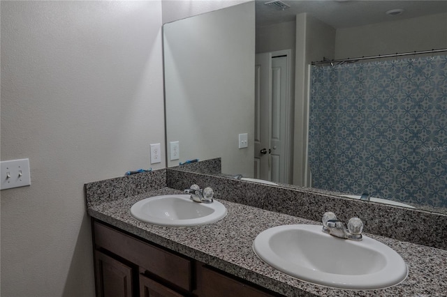 bathroom featuring a sink, a shower with shower curtain, double vanity, and visible vents