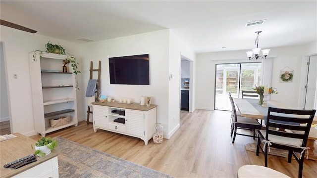 1849 Del Robles Dr, Clearwater, FL 33764 - living room with baseboards, light wood finished floors, a chandelier, and visible vents