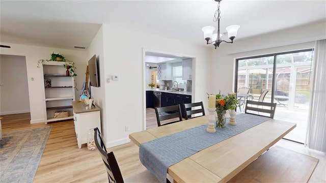 1849 Del Robles Dr, Clearwater, FL 33764 - dining room featuring light wood-style floors, baseboards, visible vents, and an inviting chandelier