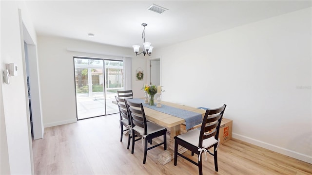 1849 Del Robles Dr, Clearwater, FL 33764 - dining room featuring an inviting chandelier, baseboards, light wood finished floors, and visible vents