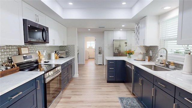 1849 Del Robles Dr, Clearwater, FL 33764 - kitchen with white cabinets, appliances with stainless steel finishes, a sink, light wood-style flooring, and a toaster
