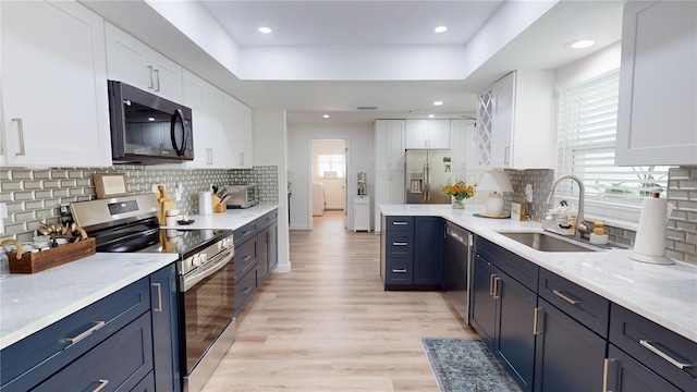 1849 Del Robles Dr, Clearwater, FL 33764 - kitchen with light wood-style floors, a sink, white cabinetry, and stainless steel appliances