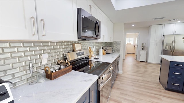 1849 Del Robles Dr, Clearwater, FL 33764 - kitchen with appliances with stainless steel finishes, light wood-type flooring, white cabinetry, and visible vents