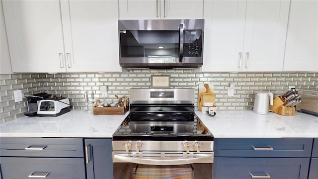 1849 Del Robles Dr, Clearwater, FL 33764 - kitchen featuring light countertops, appliances with stainless steel finishes, decorative backsplash, and white cabinetry