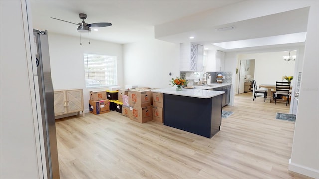 1849 Del Robles Dr, Clearwater, FL 33764 - kitchen featuring a sink, a peninsula, light countertops, a ceiling fan, and light wood finished floors