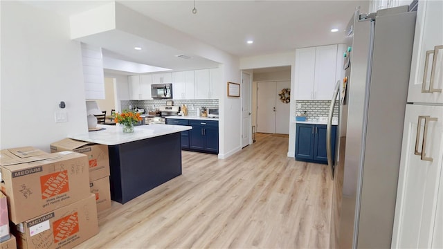 1849 Del Robles Dr, Clearwater, FL 33764 - kitchen with blue cabinetry, tasteful backsplash, light countertops, white cabinets, and stainless steel appliances