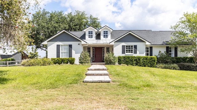new england style home featuring stucco siding, fence, and a front yard