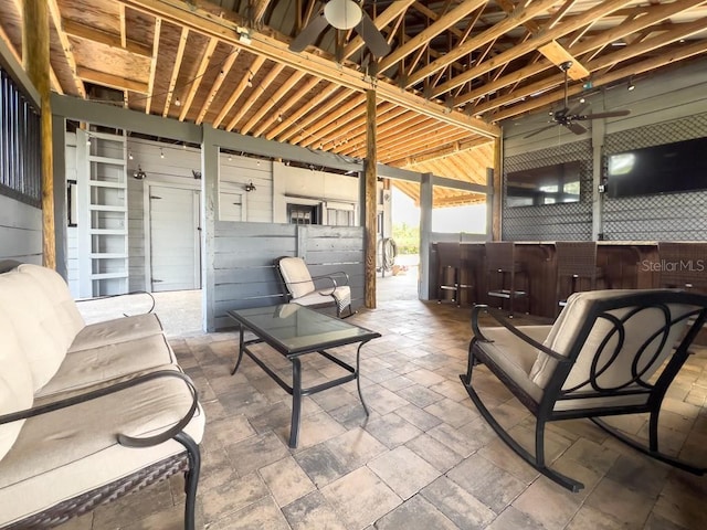 view of patio with exterior bar and a ceiling fan