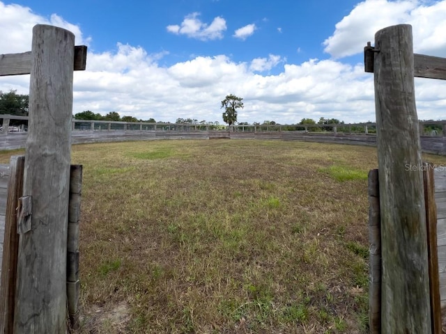 view of yard featuring fence and a rural view
