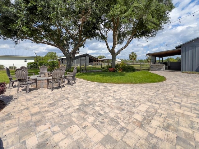 view of patio featuring a fire pit and fence