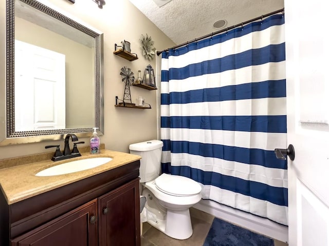 bathroom with a shower with curtain, a textured ceiling, vanity, tile patterned floors, and toilet