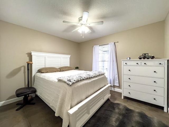 bedroom with a ceiling fan, baseboards, and dark tile patterned floors
