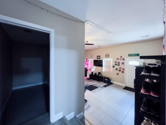 hall with baseboards and tile patterned floors