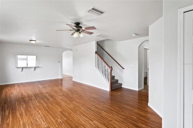 1506 Lenton Rose Ct, Trinity, FL 34655 - unfurnished living room featuring a ceiling fan, visible vents, arched walkways, wood finished floors, and stairway