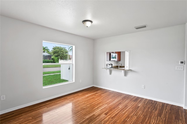 1506 Lenton Rose Ct, Trinity, FL 34655 - unfurnished room featuring a sink, baseboards, wood finished floors, and visible vents