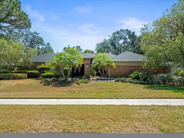 view of front facade with brick siding and a front yard