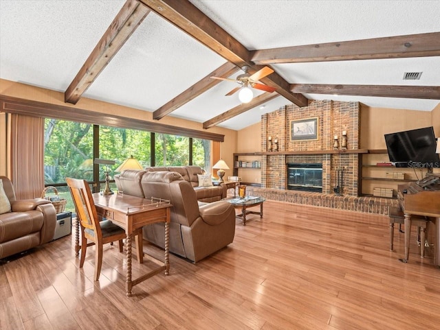 living room featuring ceiling fan, a textured ceiling, visible vents, wood finished floors, and lofted ceiling with beams