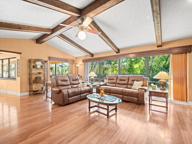 living area featuring baseboards, a ceiling fan, a textured ceiling, and light wood-style flooring