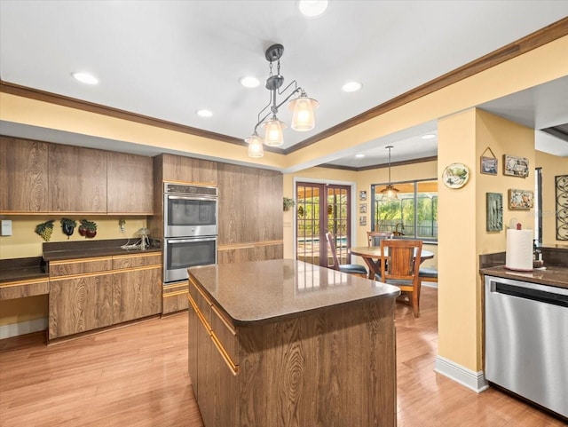 kitchen featuring crown molding, pendant lighting, light wood-style floors, recessed lighting, and appliances with stainless steel finishes