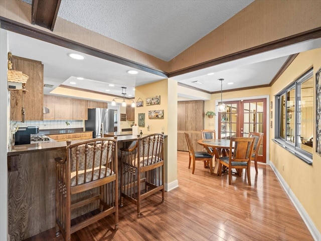kitchen featuring freestanding refrigerator, recessed lighting, dark countertops, and baseboards