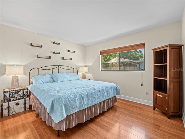 bedroom with baseboards and light wood finished floors