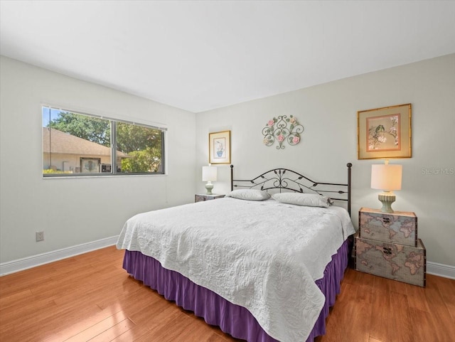 bedroom featuring baseboards and wood finished floors