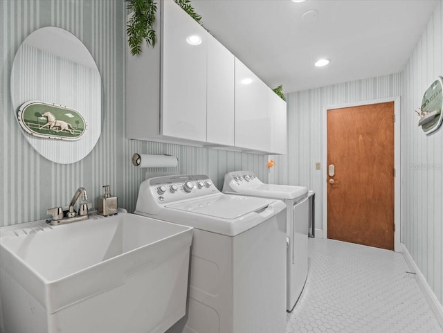 laundry area with independent washer and dryer, cabinet space, a sink, baseboards, and wallpapered walls