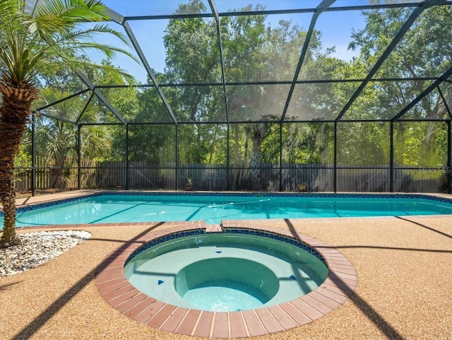 view of pool with a fenced backyard, glass enclosure, and a pool with connected hot tub