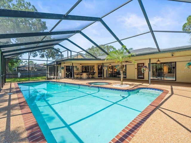 view of swimming pool featuring fence, a fenced in pool, an in ground hot tub, a patio area, and a lanai