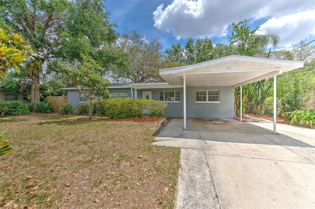 view of front facade with fence, driveway, a front yard, and a carport