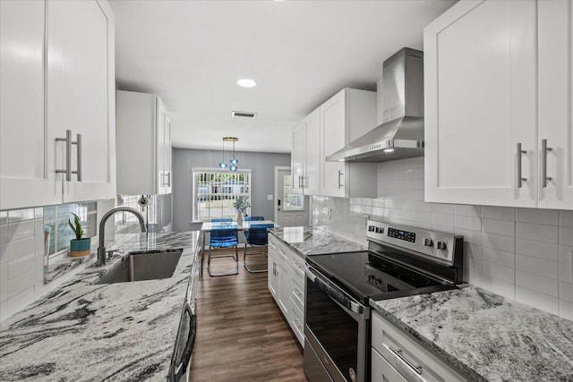 kitchen with white cabinets, stainless steel range with electric cooktop, a sink, wall chimney exhaust hood, and visible vents