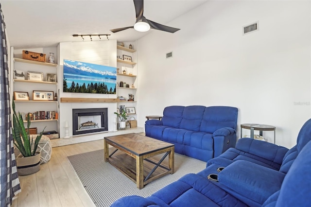 1502 Creekbend Dr, Brandon, FL 33510 - living room with ceiling fan, visible vents, a large fireplace, vaulted ceiling, and wood finished floors
