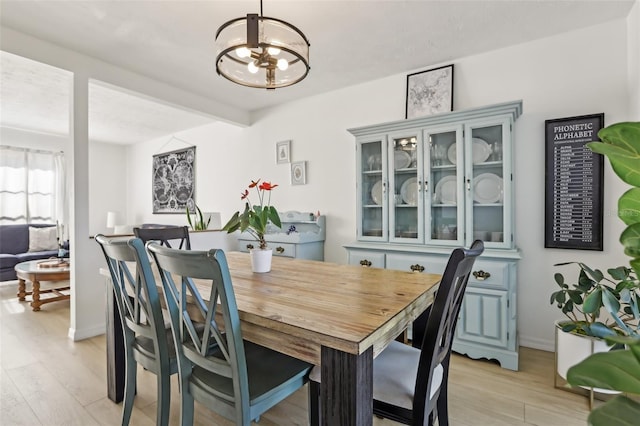 1502 Creekbend Dr, Brandon, FL 33510 - dining room featuring light wood finished floors, a chandelier, and beamed ceiling