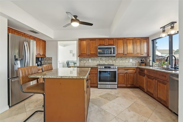 1502 Creekbend Dr, Brandon, FL 33510 - kitchen featuring brown cabinetry, a tray ceiling, tasteful backsplash, a sink, and stainless steel appliances