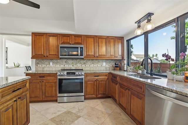 1502 Creekbend Dr, Brandon, FL 33510 - kitchen with a sink, brown cabinetry, stainless steel appliances, and backsplash
