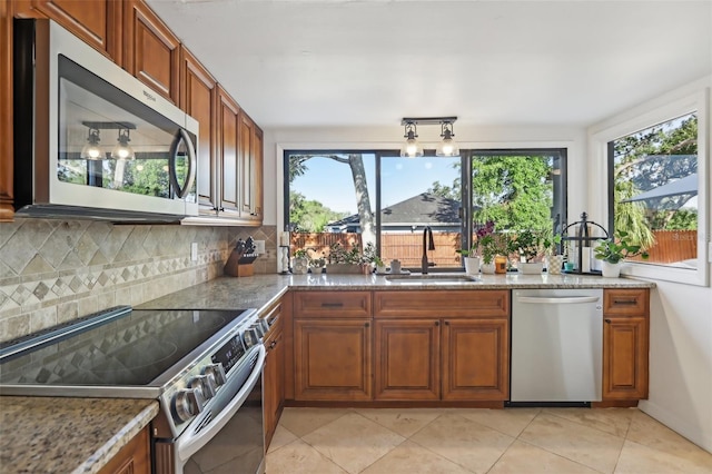 1502 Creekbend Dr, Brandon, FL 33510 - kitchen with a sink, appliances with stainless steel finishes, brown cabinets, and a healthy amount of sunlight