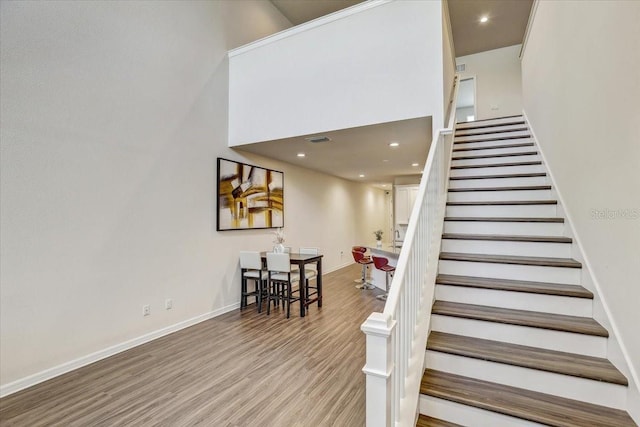 stairs with recessed lighting, baseboards, visible vents, and wood finished floors
