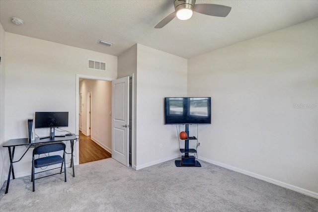 office featuring visible vents, carpet flooring, baseboards, and a ceiling fan