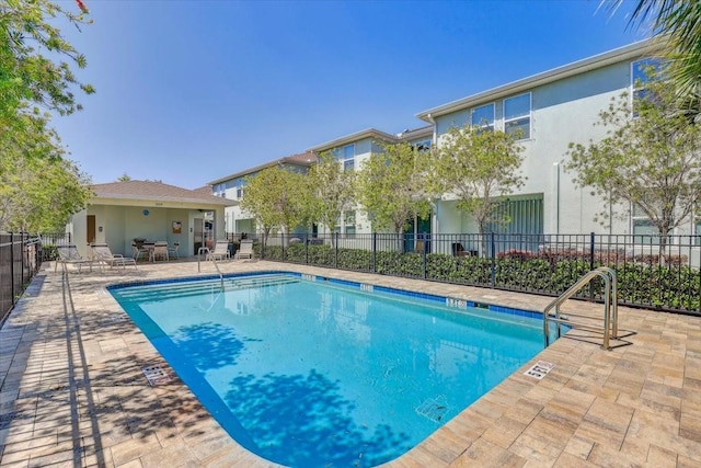 community pool featuring a patio and fence