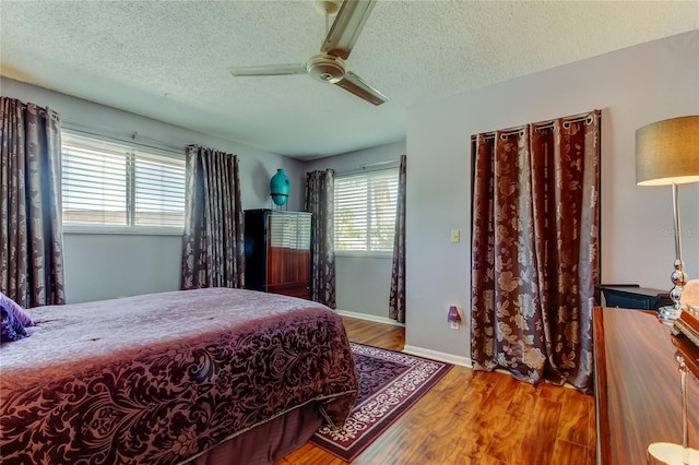 2600 Forest Run Ct, Clearwater, FL 33761 - bedroom featuring a textured ceiling, wood finished floors, ceiling fan, and baseboards