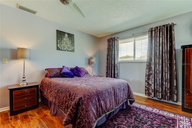 2600 Forest Run Ct, Clearwater, FL 33761 - bedroom featuring a textured ceiling, wood finished floors, and baseboards