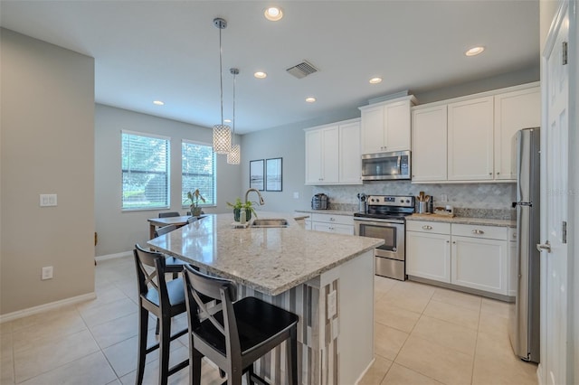 kitchen with a sink, white cabinets, stainless steel appliances, and visible vents
