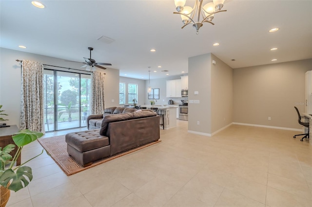 living room with light tile patterned floors, baseboards, ceiling fan with notable chandelier, and recessed lighting