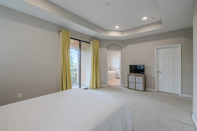 carpeted bedroom featuring recessed lighting, baseboards, a tray ceiling, and ensuite bathroom