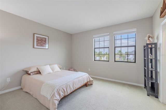 bedroom with baseboards and light colored carpet