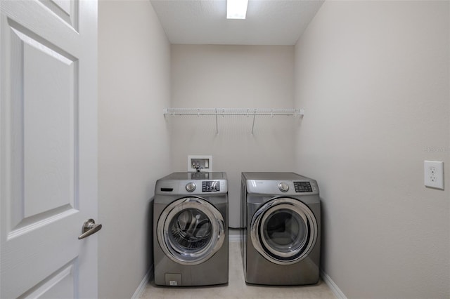 washroom with laundry area, baseboards, and washer and dryer