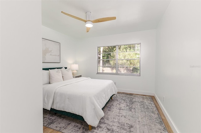 bedroom with baseboards, a ceiling fan, and wood finished floors