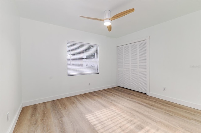 unfurnished bedroom with a ceiling fan, baseboards, wood finished floors, and a closet